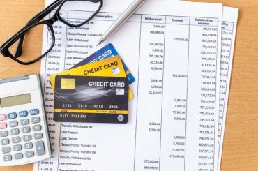 Baixar cartões de crédito e calculadora no extrato bancário em uma mesa de madeira gratuitamente